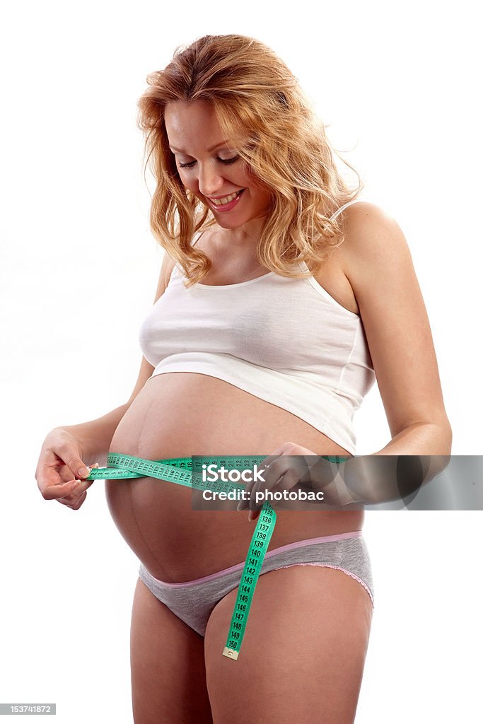 Jovem mulher grávida medir sua barriga e sorrir - Royalty-free Abdómen Foto de stock