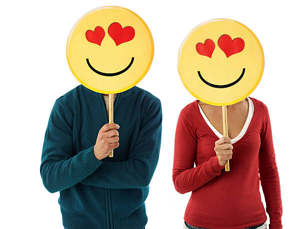 couple with emoticon young adult woman and man holding emoticon with red hearts on white background. Horizontal shape, front view, waist up anthropomorphic smiley face photos stock pictures, royalty-free photos & images