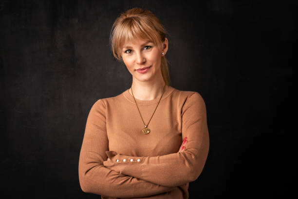 istock Blond haired attractive female standing against isolated dark background 1537425692