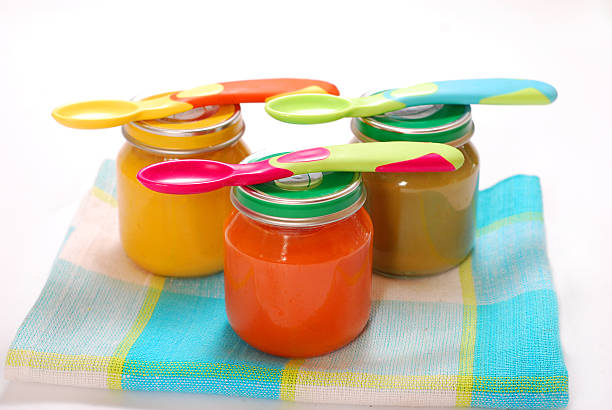 jars of baby food jars of various baby food and spoons isolated on white baby food stock pictures, royalty-free photos & images