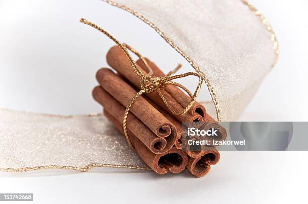 Stack Of Cinnamon Sticks Decorated With Gold Ribbons Stock Photo - Download Image Now