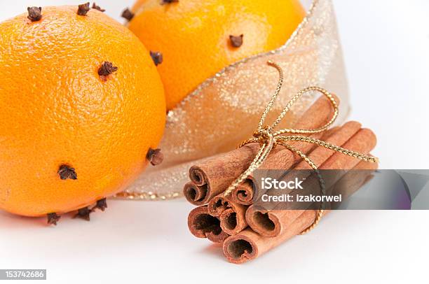 Closeup Of Two Clovesdecorated Oranges And Cinnamon Sticks Stock Photo - Download Image Now