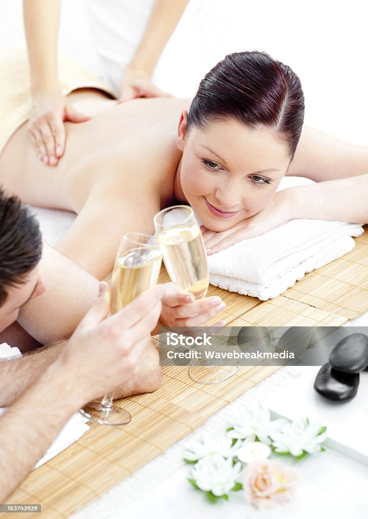 Caucasian young couple enjoying a back massage and drinking champagne Caucasian young couple enjoying a back massage and drinking champagne in a spa center Adult Stock Photo