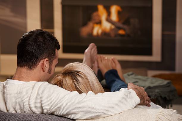 pareja abrazándose en su hogar - comfortable relaxation sofa men fotografías e imágenes de stock