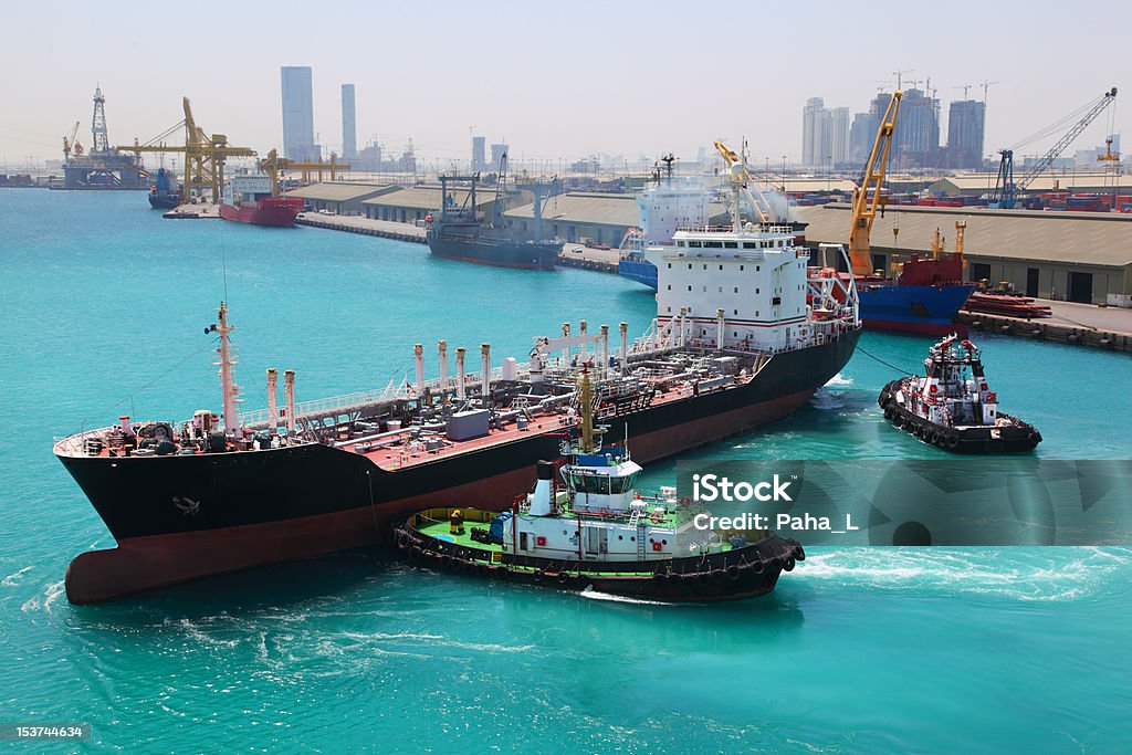 Zwei kleine Boote gehen auf Industriell genutztes Schiff im Hafen - Lizenzfrei Abu Dhabi Stock-Foto