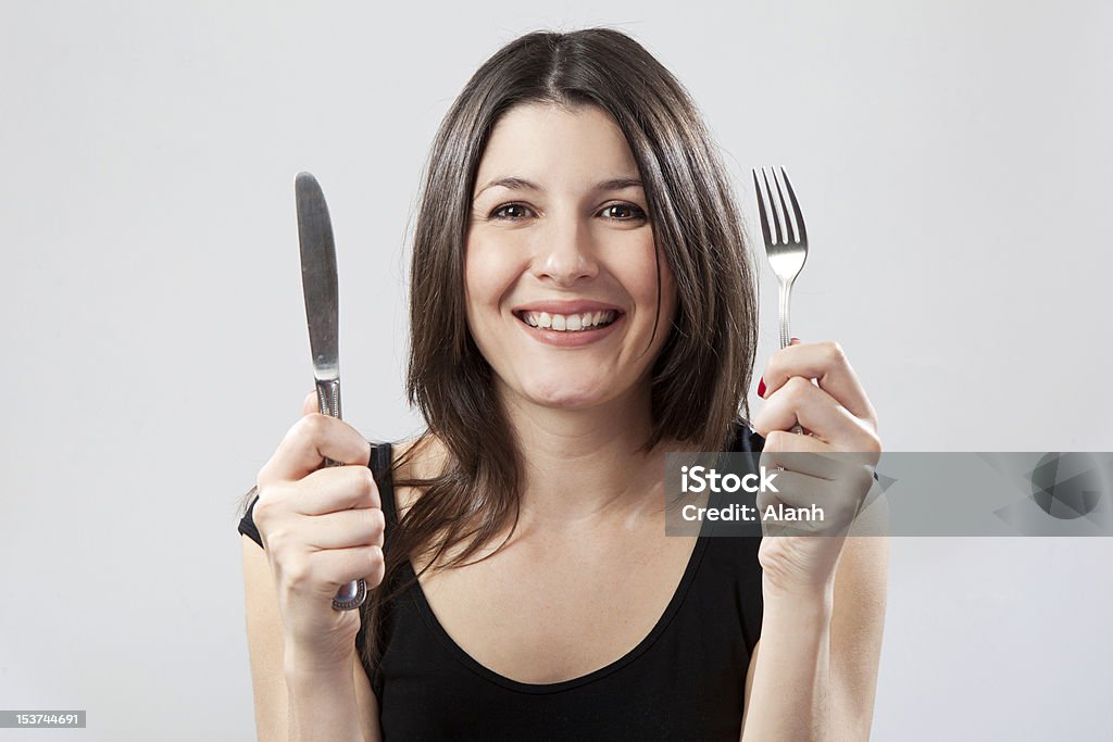 Young woman holding knife and fork Fork Stock Photo