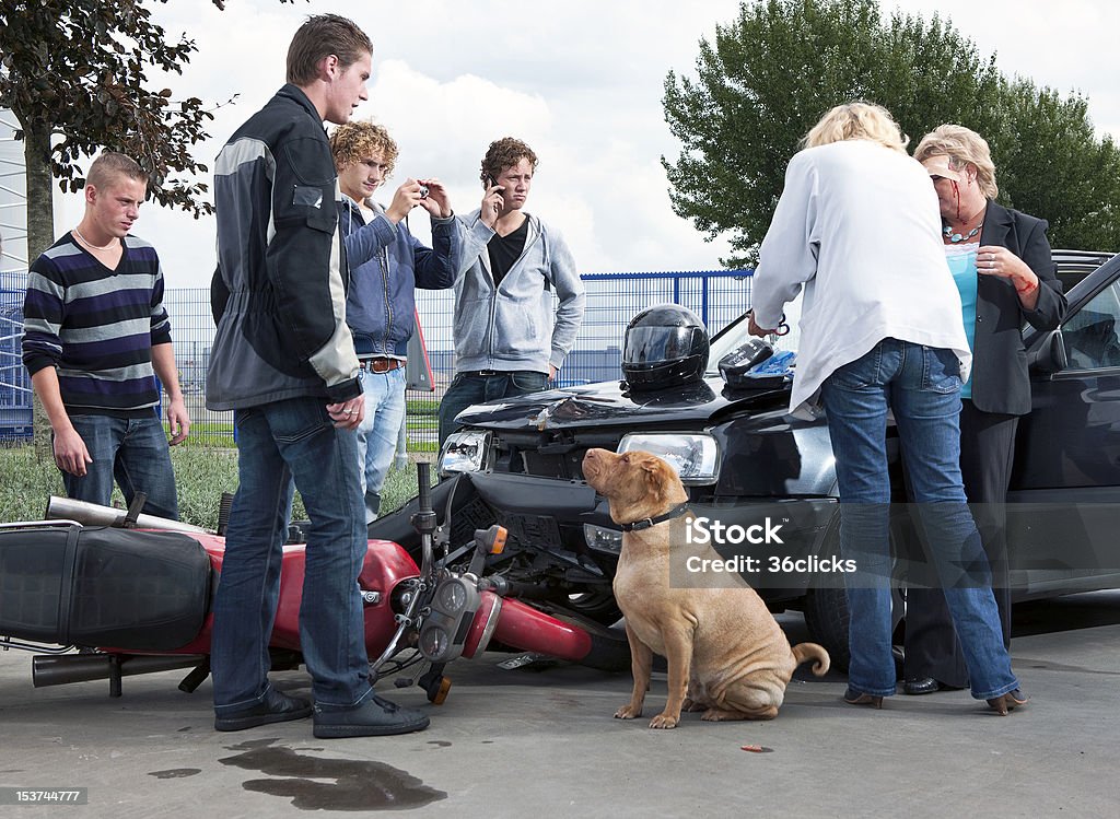 Collision Bystanders creating amateur news casts and providing first aid to the victims of an accident between a motorcycle and a car Motorcycle Stock Photo