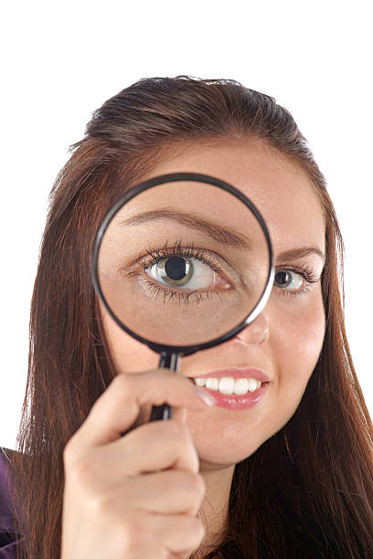 istock Smiling girl looking through magnifying glass 153744858