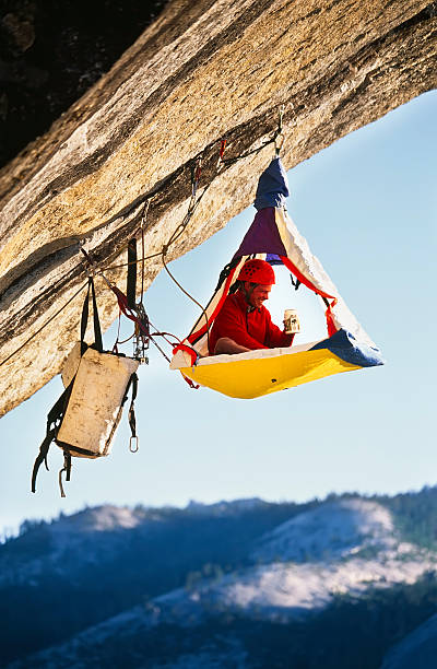 Rock climber bivouaced in a portaledge. stock photo