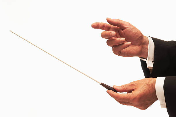 Music conductor wearing a suit and holding a baton stock photo