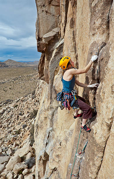istock Female rock climber clinging to a cliff. 153746079