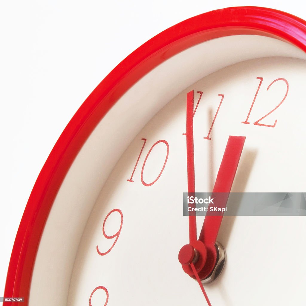 A red clock showing five minutes to midnight Clocks showing five minutes before twelve to symbolize possible upcoming danger, threat or even doom. In Front Of Stock Photo