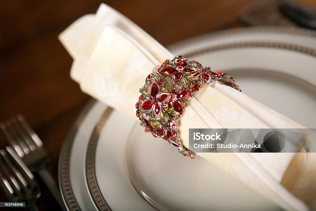 Holiday napkin ring Cream colored festive napkin with ornate fancy napkin ring on a holiday table Decoration Stock Photo