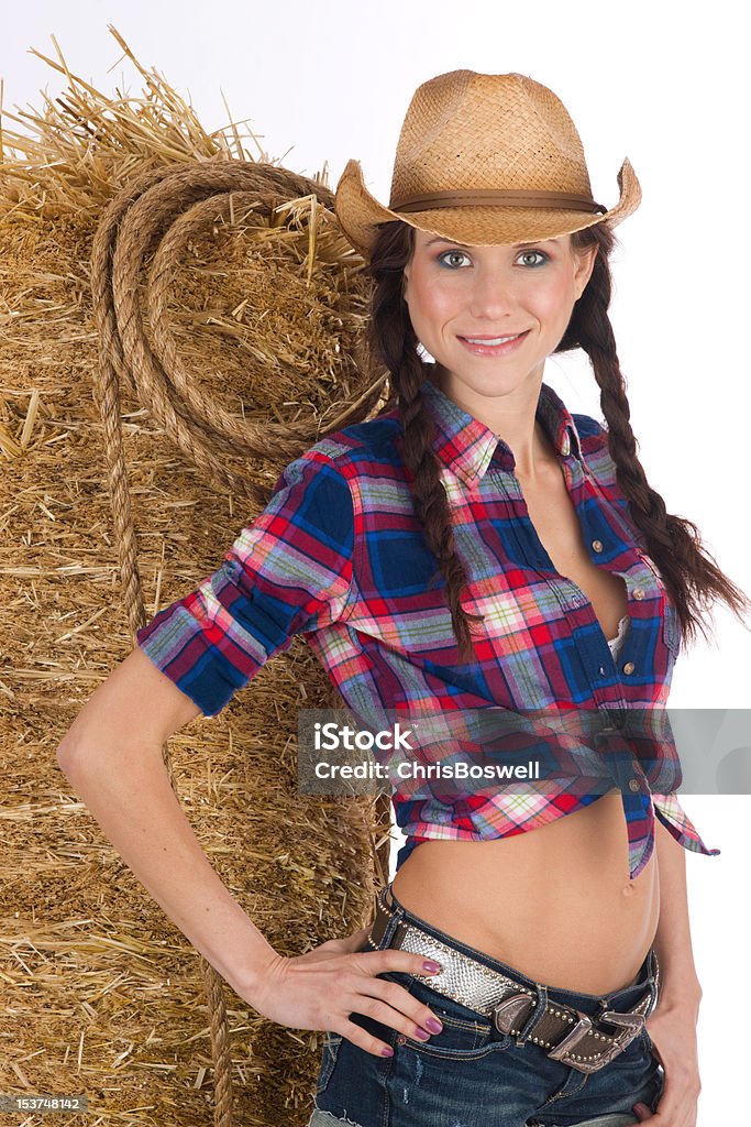 Ouest de cow-girl debout femme s'appuyant sur paille foin Bale - Photo de Abdomen libre de droits