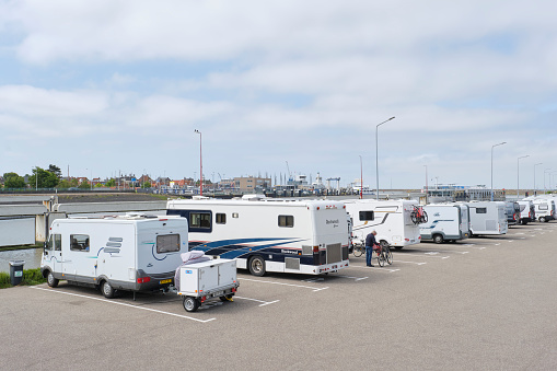 Harlingen, The Netherlands - June 8 2023: Camper place Tsjerk Hiddessluizen in Harlingen with a view of the water and the city under a cloudy sky.