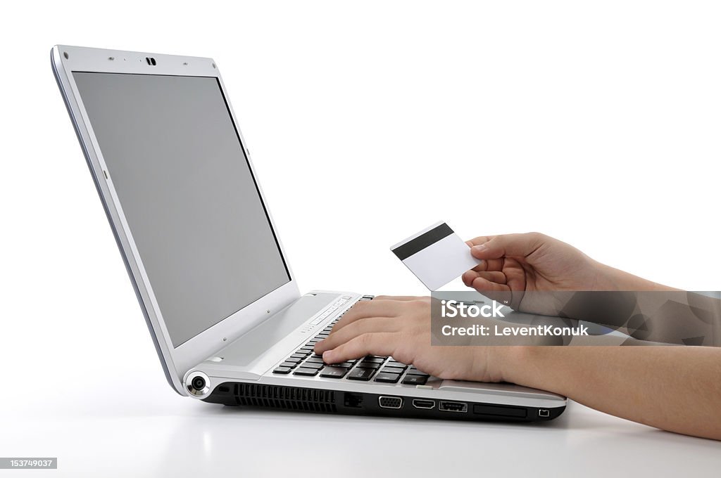 Buying online using a credit card Teen girl shopping through internet using her credit card isolated on white background.    Communication Stock Photo