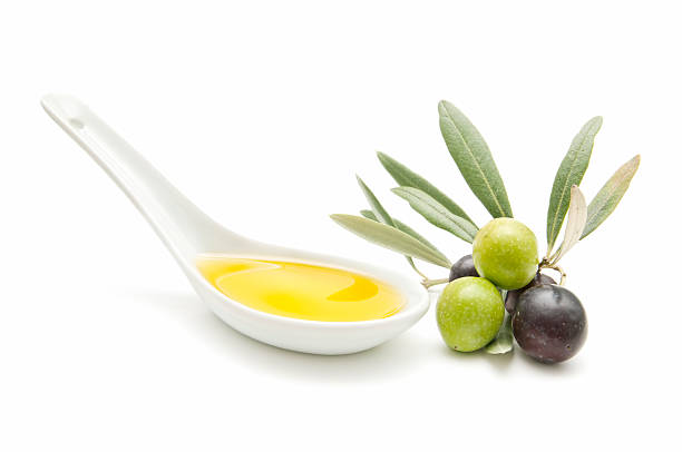 istock Spoon of olive oil with olives on white surface 153749190