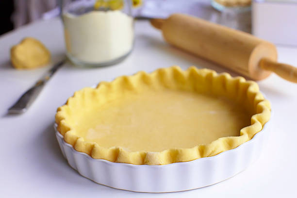Prepared pie pastry with bakery materials in the background