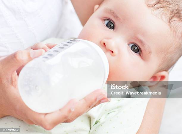 Foto de Closeup De Um Bebê Bebendo Leite Nos Braços De Sua Mãe e mais fotos de stock de Bebê