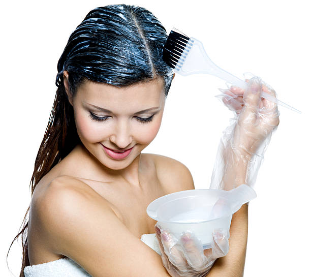 Woman wearing plastic gloves applying hair dye with brush Portrait of beautiful young woman dyeing hairs - isolated on white flaxen hair color stock pictures, royalty-free photos & images