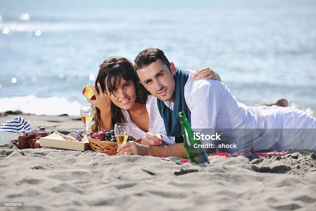 Junges Paar genießen ein Picknick am Strand - Lizenzfrei Alkoholisches Getränk Stock-Foto