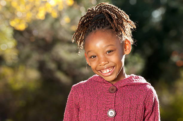 Young African American girl enjoying nice sunny day in a park.