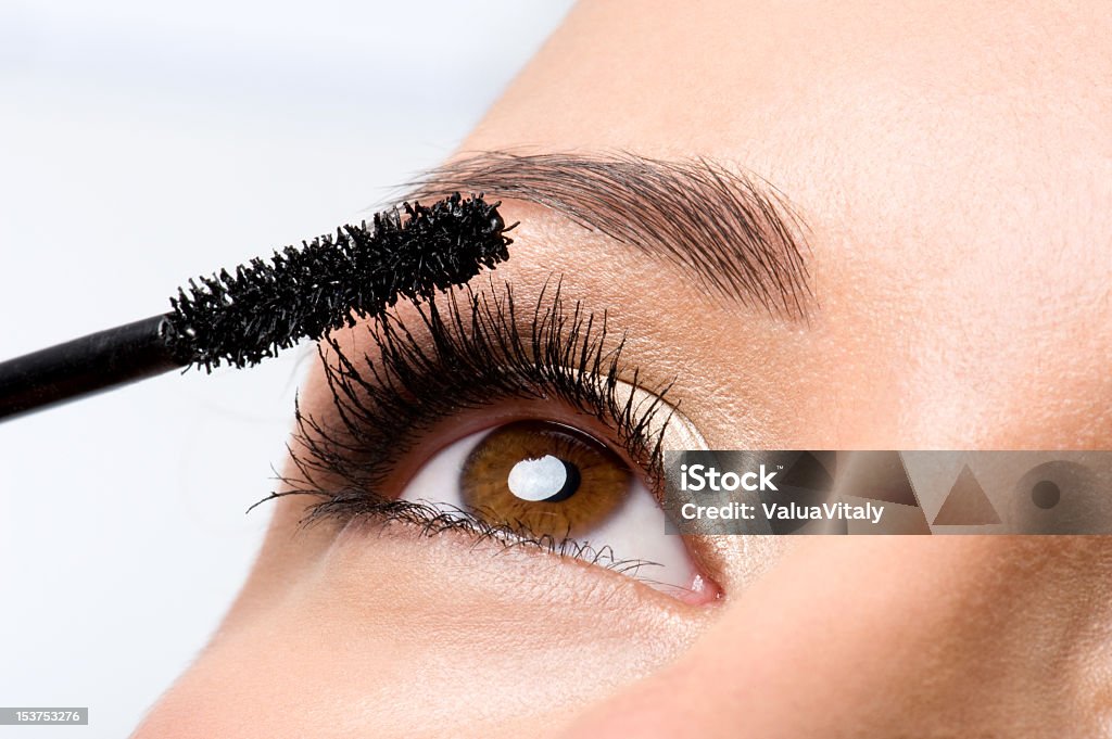 Woman applying mascara on eyelashes Woman applying mascara on her eyelashes - macro shot Eye Stock Photo