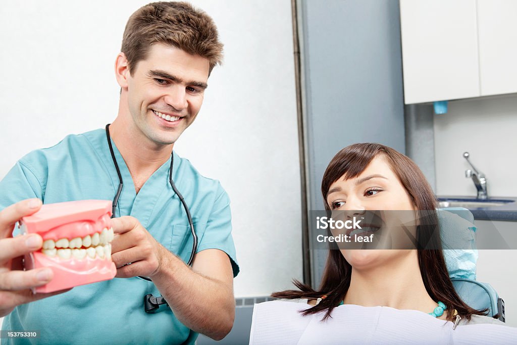 Dental Clinic Patient Male dentist explaining a female patient denture work in dental clinic 25-29 Years Stock Photo