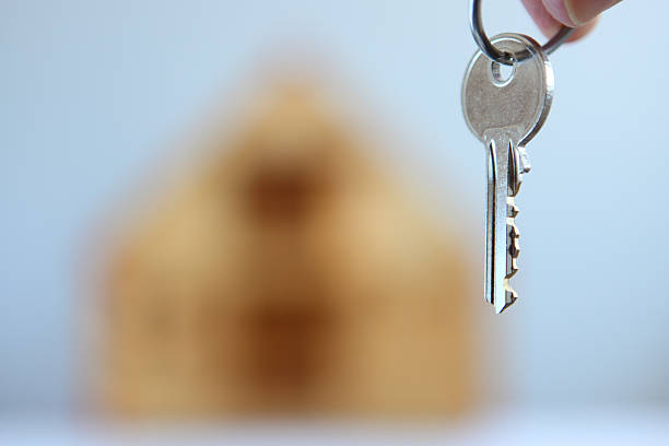 istock handing key over in front of house 153753845