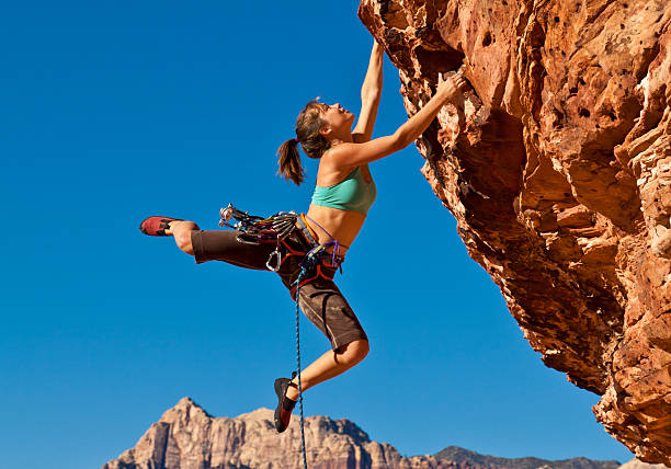 istock Female rock climber clinging to a cliff 153753962