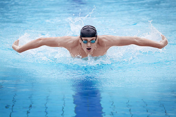 pływak w cap oddychaniem wykonujących styl motylkowy - butterfly swimming zdjęcia i obrazy z banku zdjęć