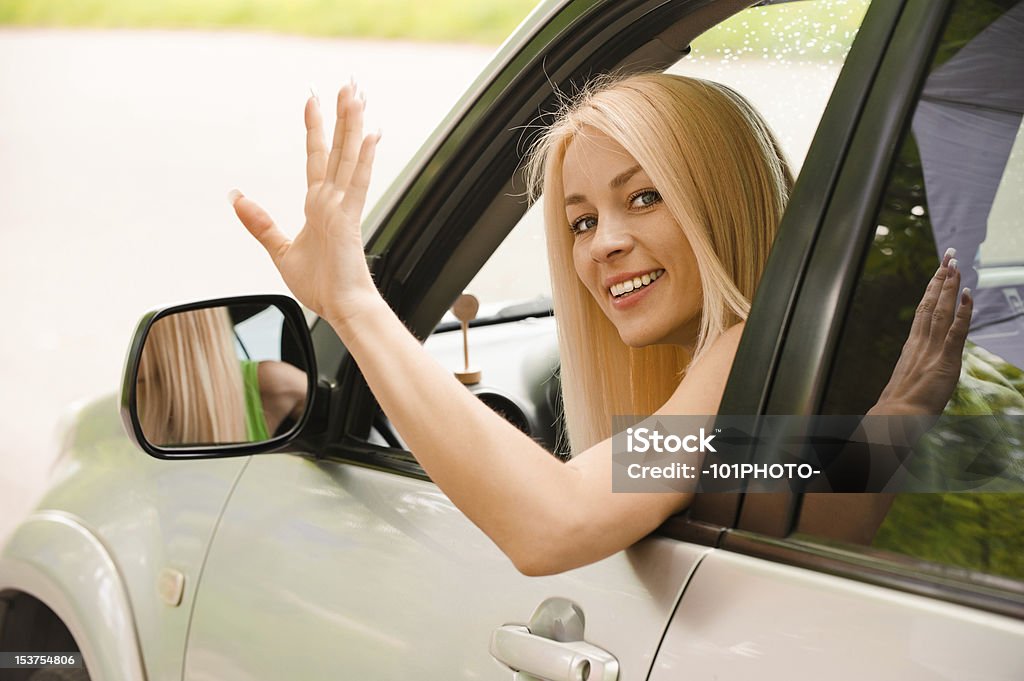 Driver-woman of car waves back Driver-woman of car waves back as sign of farewell. Car Stock Photo