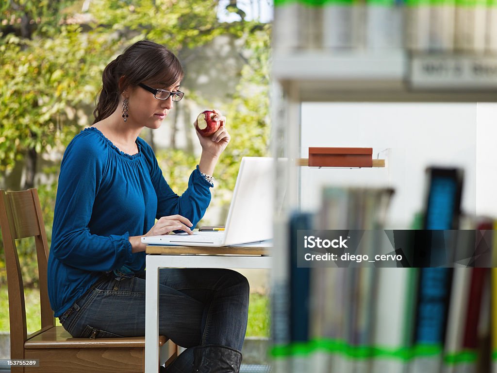 girl holding manzana de la biblioteca - Foto de stock de 20 a 29 años libre de derechos