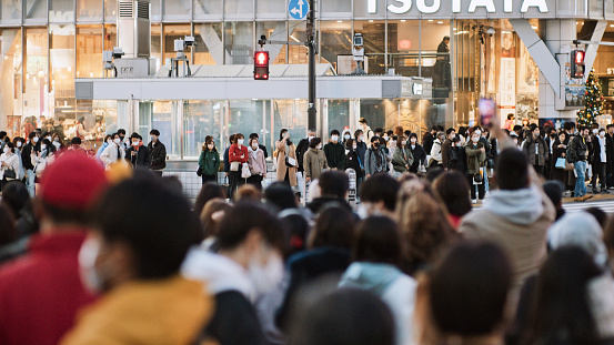 Crowd of Japanese, Asian people, tourist traveler walk cross road at Shibuya scramble crossing in Tokyo. Japan tourist attraction, travel landmark, Asia transportation city life concept
