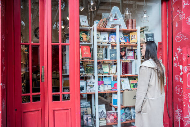 istock Young woman looking books on library showcase 1537566255