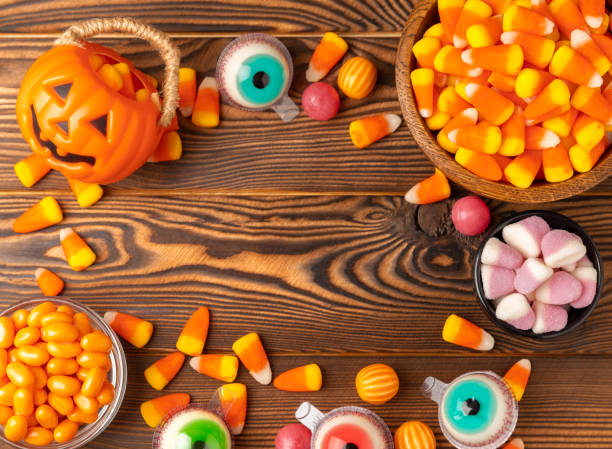 istock Halloween candy corn,jelly eye, pumpkin candy, sugar skull in different bowls on background.Classic candy sweets for Halloween with.Halloween holiday concept with candy corn and jack o lantern. 1537573676