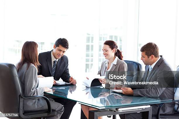 Vier Geschäftsleute Während Einer Tagung Stockfoto und mehr Bilder von Akte - Akte, Aktenordner, Arbeiten