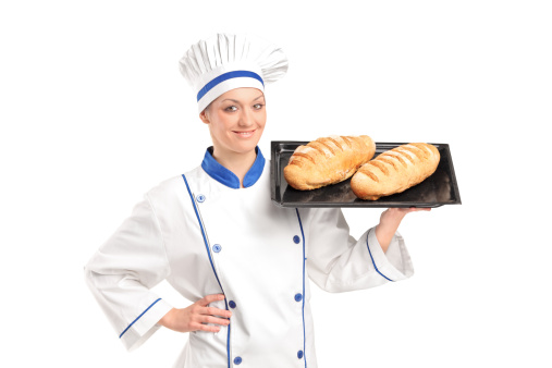 Smiling female baker showing freshly baked breads isolated on white background