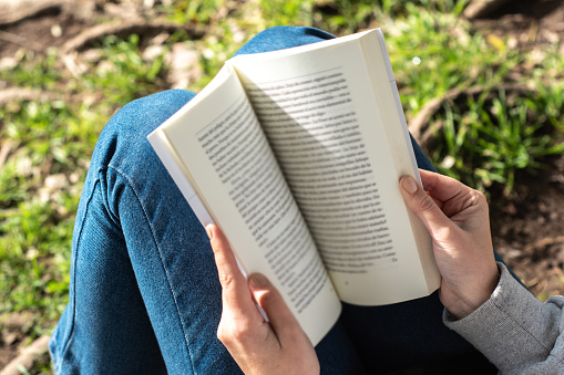 Close-up of a woman reading a book outdoors