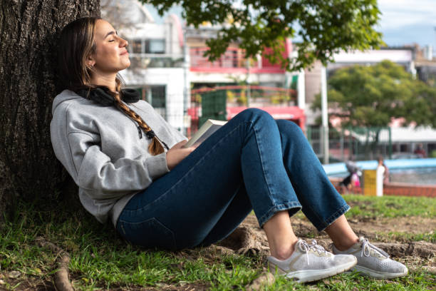 Young woman resting in tree on the public park