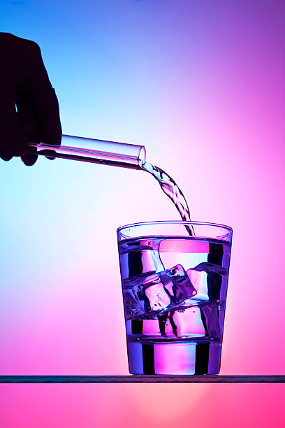 Pouring liquid from test tube into a cocktail stock photo