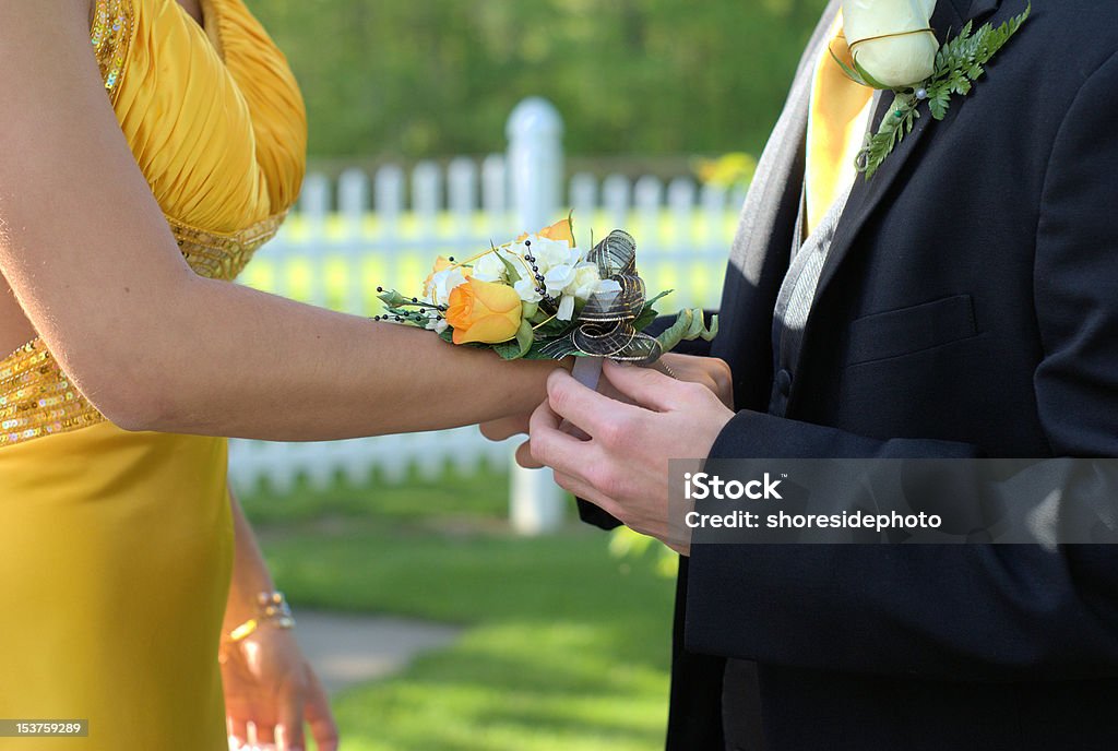 prom wedding couple corsage man placing flowers on woman's wrist for prom Prom Stock Photo