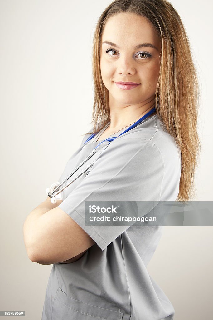 Giovane donna medico o l'infermiere con scrub - Foto stock royalty-free di Infermiera - Infermiere