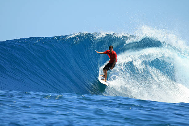 Surfer on perfect blue wave, Mentawai Islands, Indonesia Surfer on tropical blue wave in red t-shirt, Mentawai Islands, Indonesia Mentawai Islands stock pictures, royalty-free photos & images