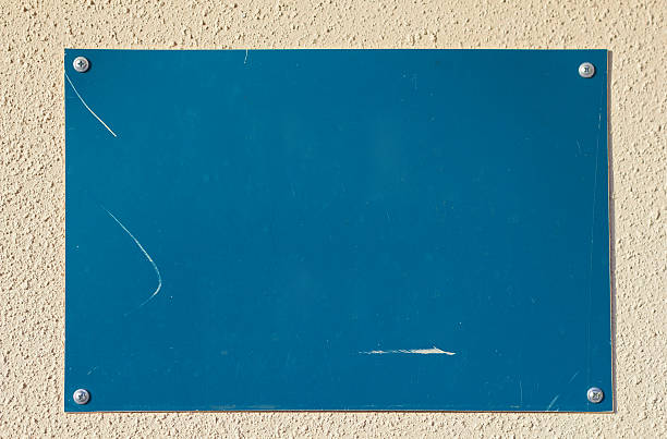 istock Closeup of empty blue board on beige concrete wall 153760124