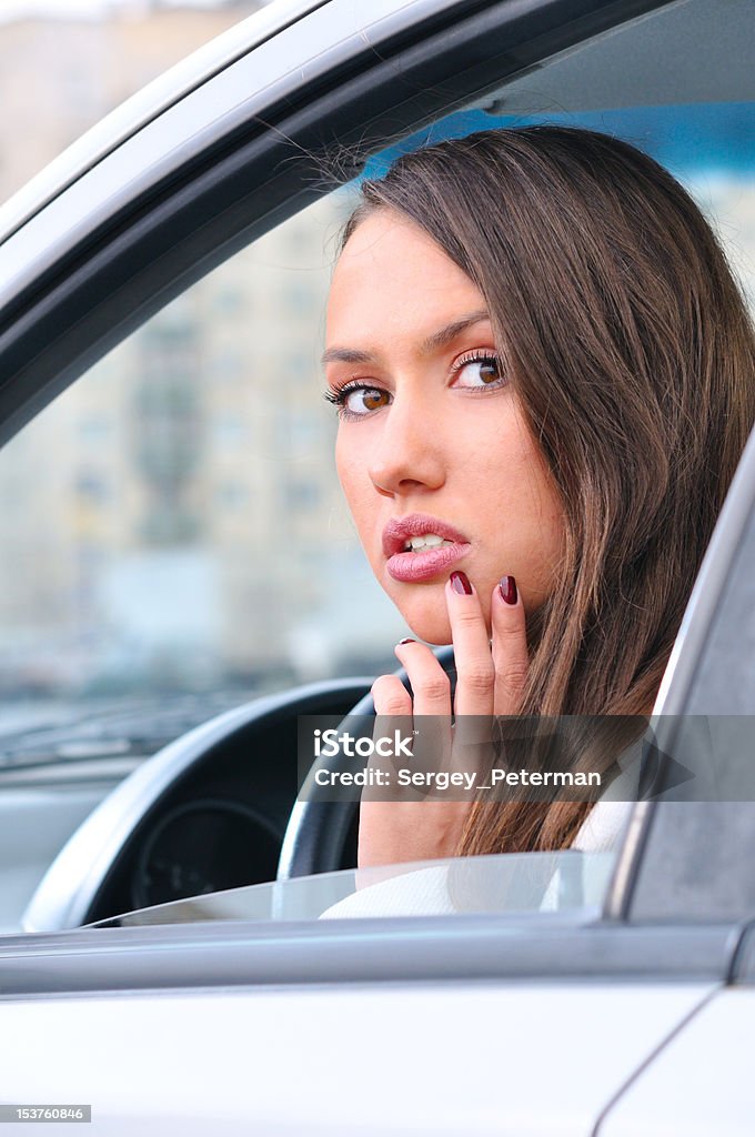 Sensuale giovane donna guardando la telecamera da un'auto - Foto stock royalty-free di Automobile