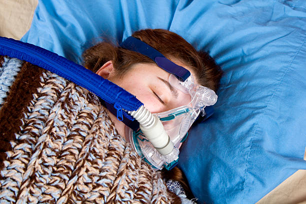 istock Woman sleeping with CPAP machine 153760960
