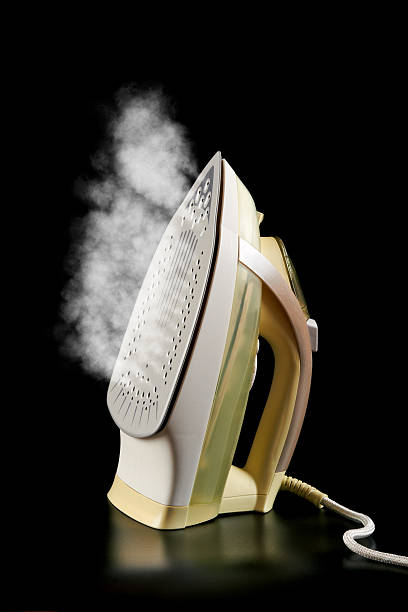 istock Shiny electric iron emiting a steam 153761134