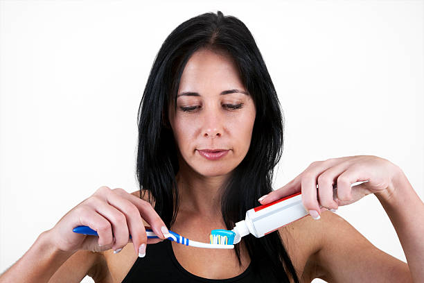 istock Woman applying toothpaste to toothbrush 153761159
