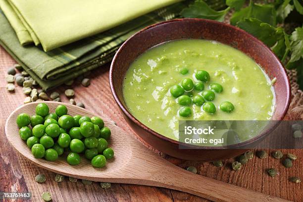 A Bowl Of Green Pea Soup With A Wooden Spoon Stock Photo - Download Image Now - Pea Soup, Green Pea, Soup